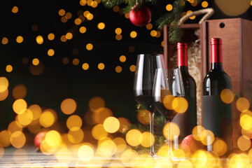 Poster - Bottles of wine, glasses, wooden boxes, fir twigs and red Christmas balls on table, space for text. Bokeh effect