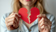 © CheeSiong - Woman holding a red broken heart in her hands