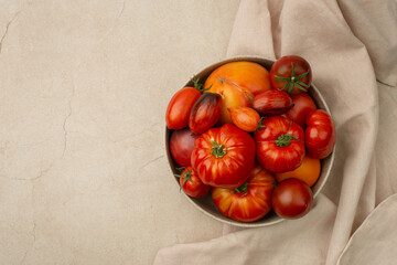 Red ripe organic tomatoes in a plate on the table