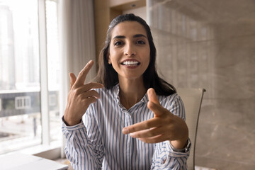 Positive Hispanic business coach woman giving online training, speaking at camera on video conference call, moving hands, using gadget for Internet communication. Head shot portrait