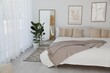 © New Africa - Large bed, houseplant and full-length mirror near window in room. Stylish bedroom interior