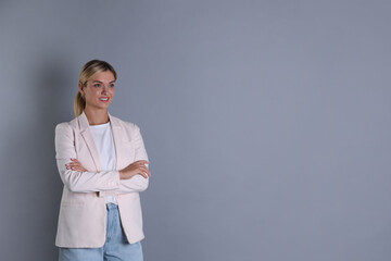 Wall Mural - Beautiful woman in stylish jacket on grey background, space for text