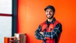 © K-MookPan - A cheerful young worker stands confidently in a bright workspace, showcasing a vibrant personality against an orange background.