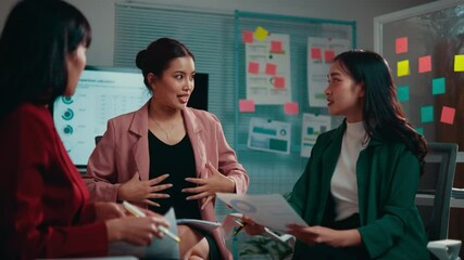 Poster - Three businesswomen are having a meeting in the office. They are discussing strategy and using charts and graphs to illustrate their points