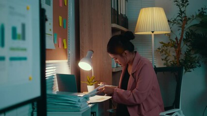 Poster - Young asian businesswoman works on documents at her desk late at night, gradually feeling tired and overwhelmed by the pressures of deadlines and the demands of her career