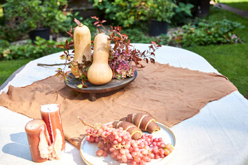 Fall table setting with pumpkins and leaves and hydrangea in brown and burgundy tones