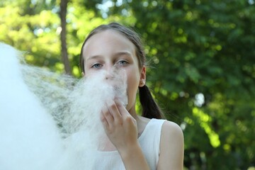 Poster - Little girl eating sweet cotton candy in park