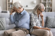 © fizkes - Sad couple going through divorce, misunderstanding sitting together on sofa aside, thinking about marriage split, unpleasant situation, betrayal or break up. Problem in relationships of mature spouses