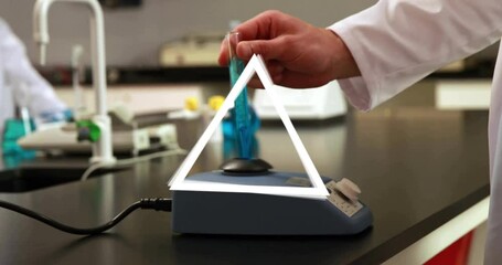 Poster - Hand holding test tube over laboratory equipment with triangle animation