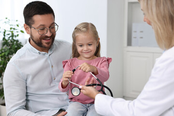 Wall Mural - Father and her little daughter having appointment with doctor in hospital