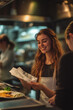© Anastasiia Ignateva - Warm Candid Shot of Smiling Waitress. Smiling young waitress in apron holding receipt in restaurant, ideal for hospitality and service industry themes.