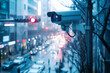© DesignByGade - A security camera mounted on a pole in a city street with a blurry view of traffic. It provides a sense of security and monitoring.