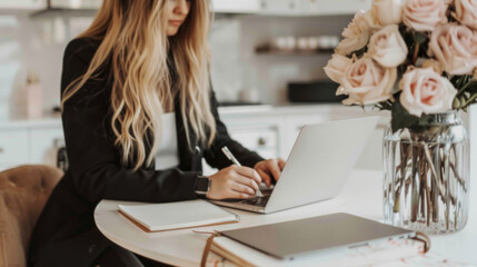Aufkleber - A woman is sitting at a table with a laptop and a notebook