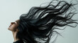 © Oksana - Artistic depiction of a woman with long black hair flowing in the air, against a neutral background. Her face is partially visible in profile, with a calm expression