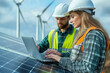 © abderahim - Engineers are inspecting solar panels wind turbines for renewable energy, wearing hard hats, using laptops, prioritizing safety. They focus on green energy employ modern technology on site