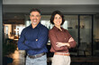© insta_photos - Happy executive managers, two business man and woman leaders entrepreneurs, corporate partners business owners professional work team standing arms crossed in office looking at camera. Portrait.