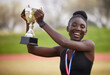 © Nina2024/peopleimages.com - Black woman, trophy and success with gold as excited for win, competition and sport celebration outdoor. Athlete, portrait and achievement with professional running, goals or podium performance award