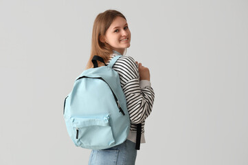 Canvas Print - Female student with backpack on grey background