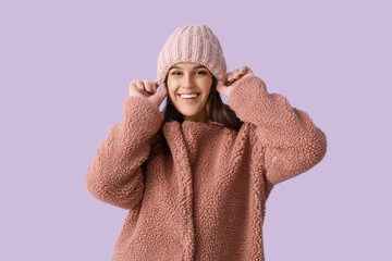 Wall Mural - Young woman in teddy coat on lilac background