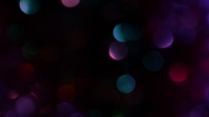 Fast moving pink red blue green black abstract shiny sparkly round bokeh background constantly moving side-to-side