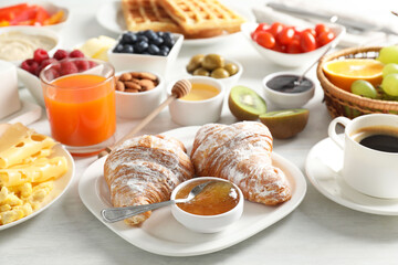 Sticker - Tasty breakfast. Croissants, jam, coffee and other food on light table, closeup