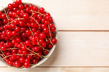 Sticker - Fresh red currant berries in bowl on white wooden table, top view. Space for text