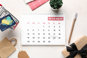 Sticker - Beautiful composition with calendar page of November 2023, shopping cart and gift box on white background. Black Friday concept