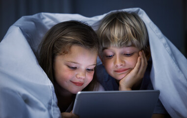 Wall Mural - Children, duvet and watching with tablet at night for online entertainment, streaming or cartoon in bed at home. Happy kids, siblings or brother and sister lying with technology for movie in bedroom