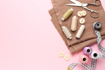 Poster - Flat lay composition with different sewing supplies on pink background. Space for text