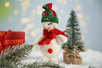 Wall Mural - Cute decorative snowman and other Christmas decor on artificial snow, closeup