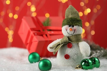 Wall Mural - Cute decorative snowman and other Christmas decor on artificial snow, closeup