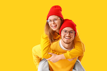 Poster - Young couple in eyeglasses on yellow background