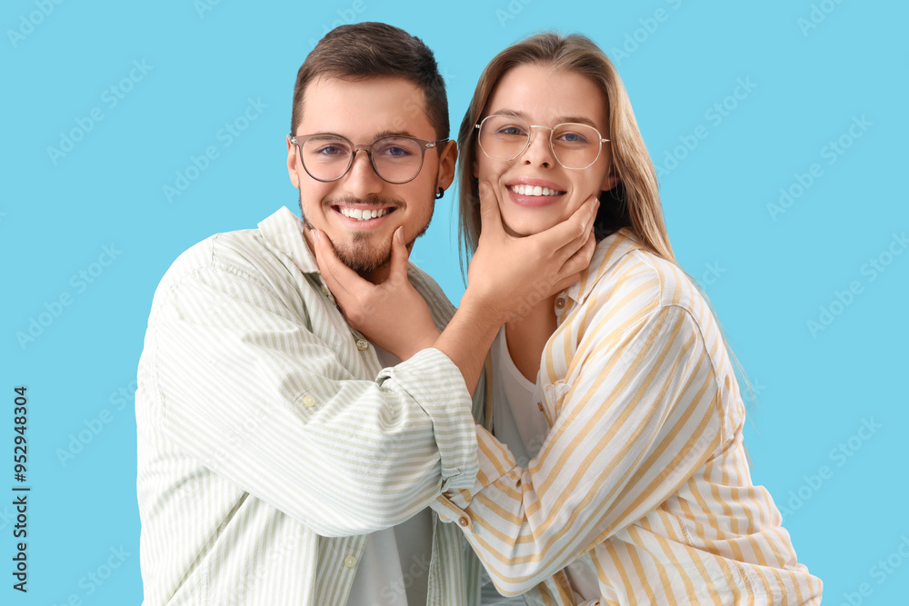 Young couple in eyeglasses on blue background