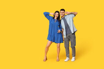 Poster - Happy young couple dancing on yellow background