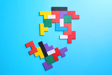 Poster - Colorful wooden puzzle pieces on light blue background, top view