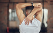 © Van Wyk/peopleimages.com - Man, fitness and stretching with arm before workout, exercise or training at indoor gym. Back view of male person or athlete in body warm up, preparation or getting ready for wellness at health club