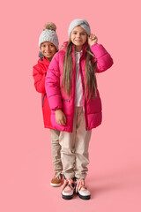 Canvas Print - Cute little happy children in winter clothes on pink background