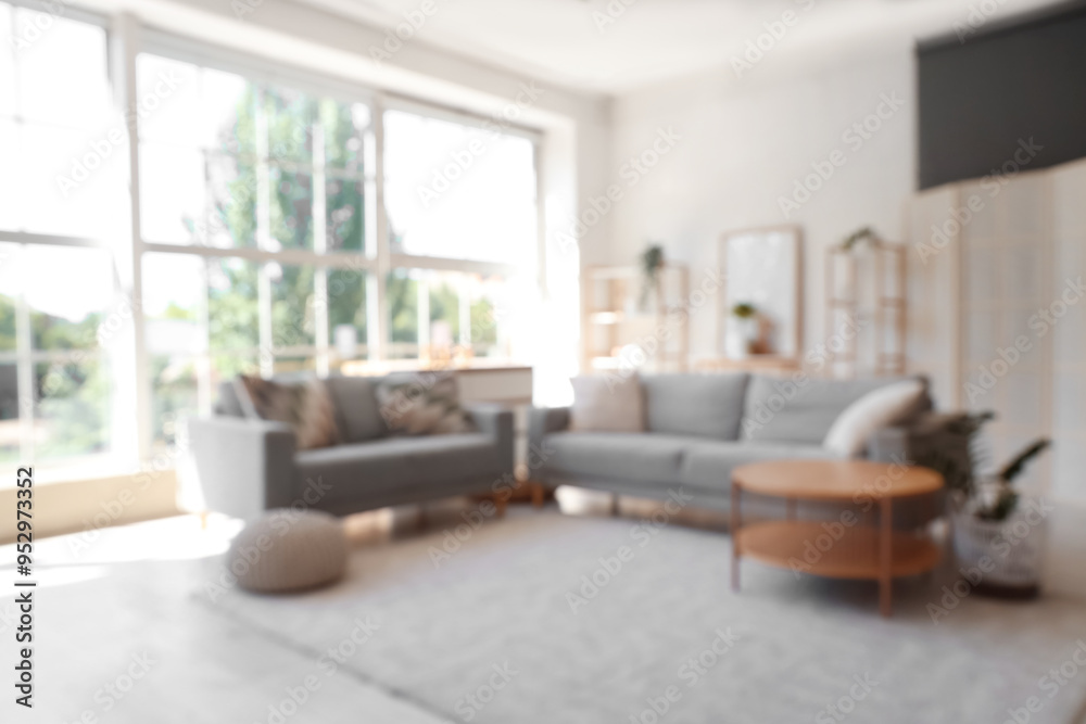 Interior of stylish modern living room with grey sofas and coffee table, blurred view