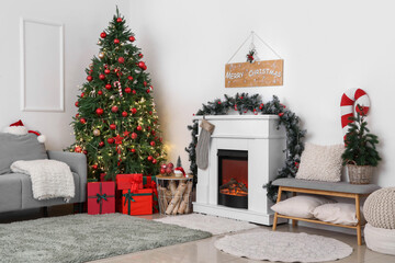 Poster - Interior of living room with glowing Christmas tree, sofa and fireplace