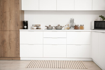 Poster - Interior of light kitchen with white counters and utensils