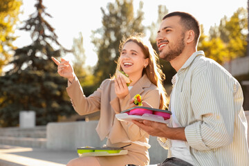 Poster - Young colleagues having lunch outdoors