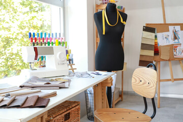 Poster - Fashion designer's workplace with sewing machine and fabric samples in studio