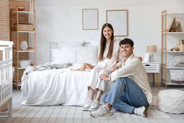 Canvas Print - Happy young parents with their little baby in bedroom