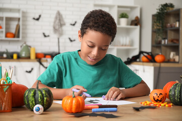 Canvas Print - Teenage African-American boy drawing Halloween picture at table