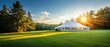 © Creative_Bringer - Large white wedding tent on lush green lawn, guests entering through open flaps, sun shining brightly