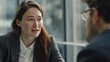 © JINGWEN - Confident businesswoman in her thirties discussing with a male colleague during an office meeting. Collaboration, communication, and professional business concepts.