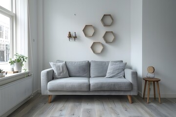 Wall Mural - A small, cozy living room in with white walls and a light grey wooden floor. The gray sofa has two decorative hexagonal shelves on the wall above it. 