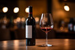 © MIIJIN - bottle of red wine next to half filled wine glass on wood table dim soft light with bokeh restaurant interior background