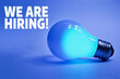 © MOTOKO Stock - Illuminated Blue Light Bulb with 'We Are Hiring' Banner: Innovative Recruitment Visual for Job Postings and HR Campaigns
