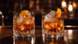 © vanAmsen - A sophisticated image featuring two old-fashioned cocktails served in heavy crystal glasses on a pol